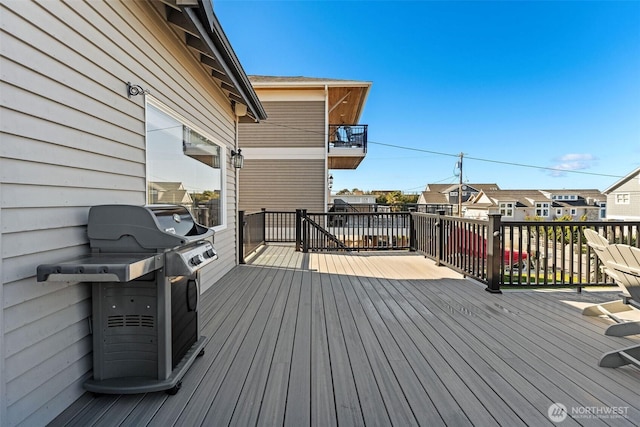 wooden terrace featuring grilling area and a residential view