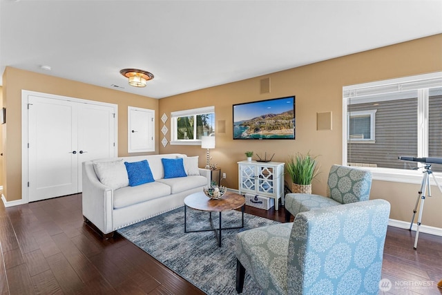 living room featuring dark wood finished floors, visible vents, and baseboards