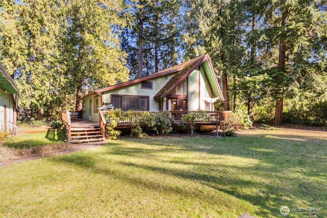 view of front of property featuring a front yard, a wooden deck, and stucco siding