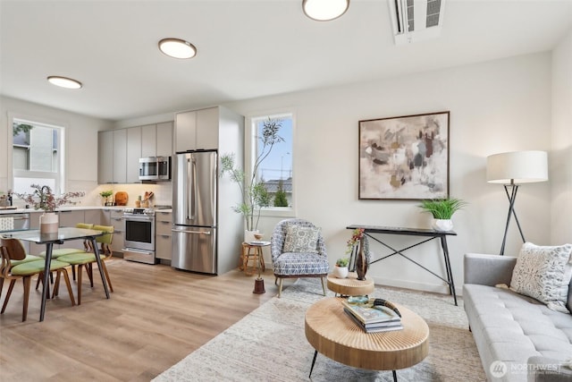 living room with visible vents and light wood-type flooring