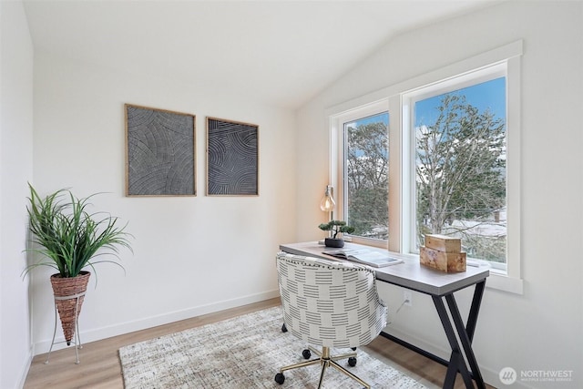 office area with baseboards, light wood-type flooring, plenty of natural light, and lofted ceiling