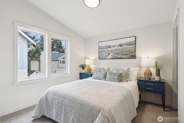 carpeted bedroom with lofted ceiling and baseboards