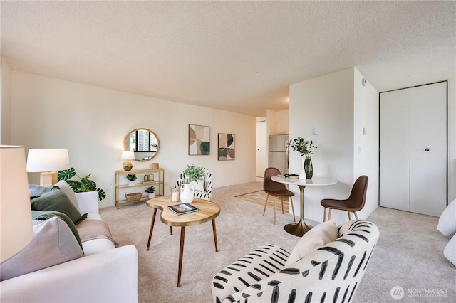 living area with light colored carpet and a textured ceiling