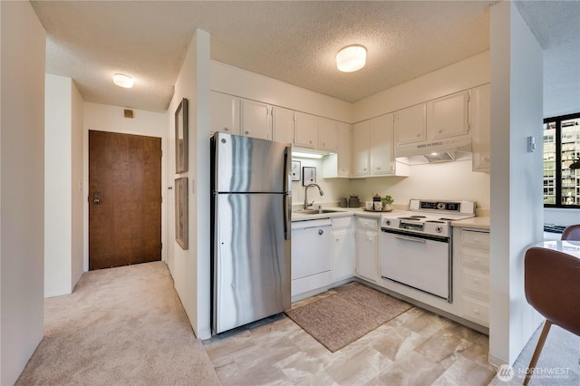 kitchen with under cabinet range hood, a sink, white cabinetry, white appliances, and light countertops