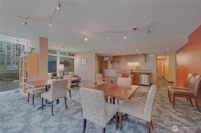 dining space featuring light colored carpet and rail lighting