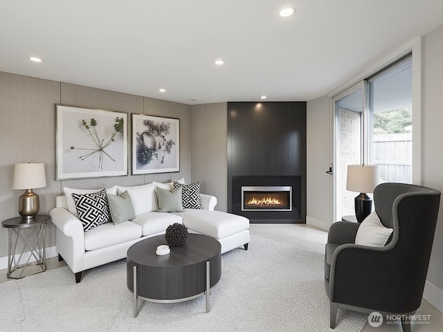 living area with recessed lighting, a large fireplace, and baseboards