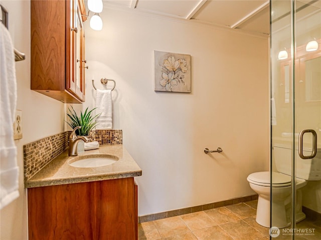 bathroom with tasteful backsplash, baseboards, toilet, vanity, and a shower stall