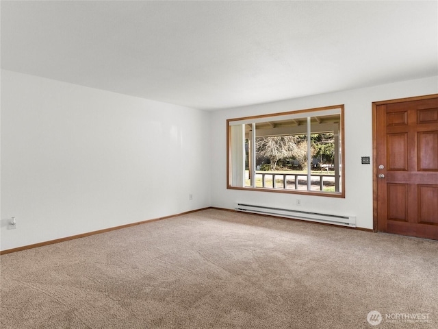 carpeted empty room featuring baseboard heating and baseboards