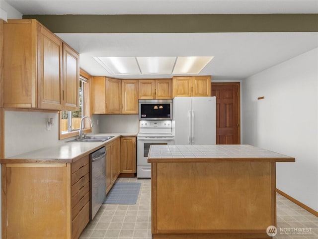 kitchen featuring baseboards, a kitchen island, stainless steel appliances, light floors, and a sink