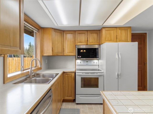 kitchen featuring stainless steel appliances, a sink, and light tile patterned floors