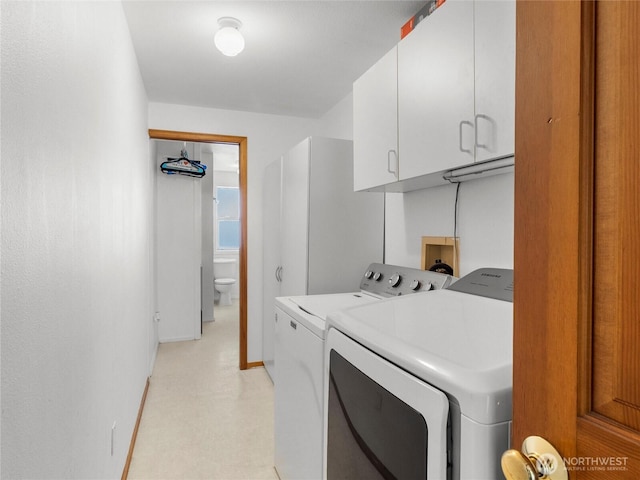 clothes washing area featuring cabinet space, independent washer and dryer, and light floors