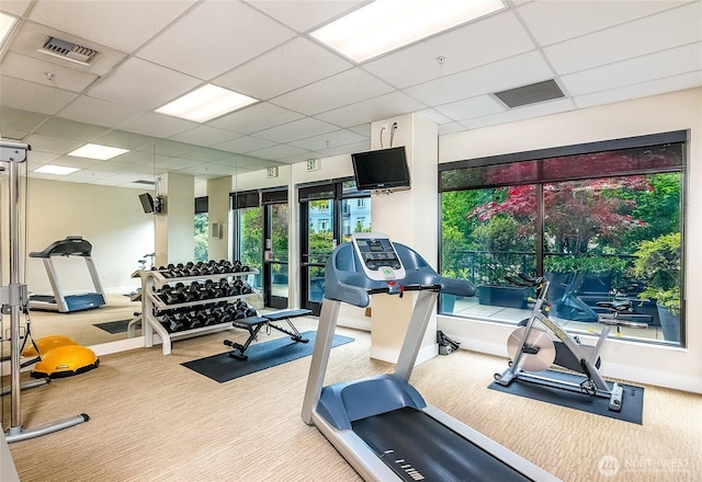 workout area featuring carpet, a paneled ceiling, visible vents, and baseboards