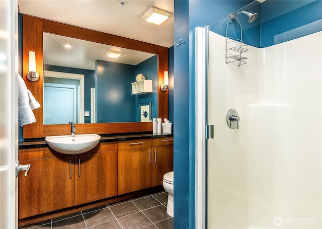 bathroom with tile patterned flooring, toilet, vanity, and a stall shower