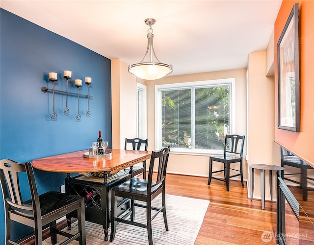 dining space with light wood-style flooring and baseboards