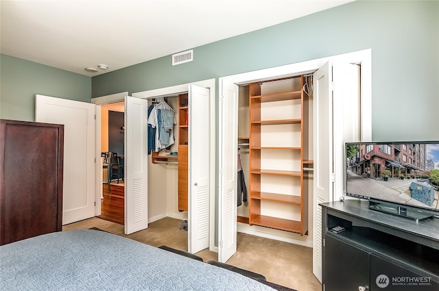 interior space featuring visible vents and multiple closets