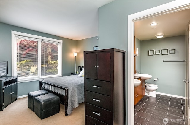 bedroom featuring baseboards and ensuite bathroom