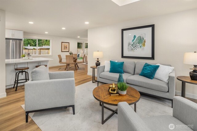 living area featuring recessed lighting, light wood-style floors, and baseboards