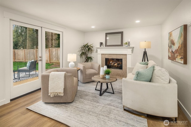 living room with baseboards, recessed lighting, a fireplace, french doors, and wood finished floors