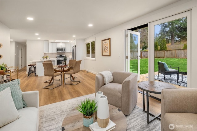 living area featuring light wood finished floors, recessed lighting, and baseboards