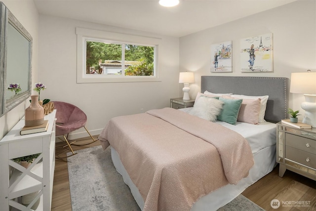 bedroom featuring wood finished floors and baseboards