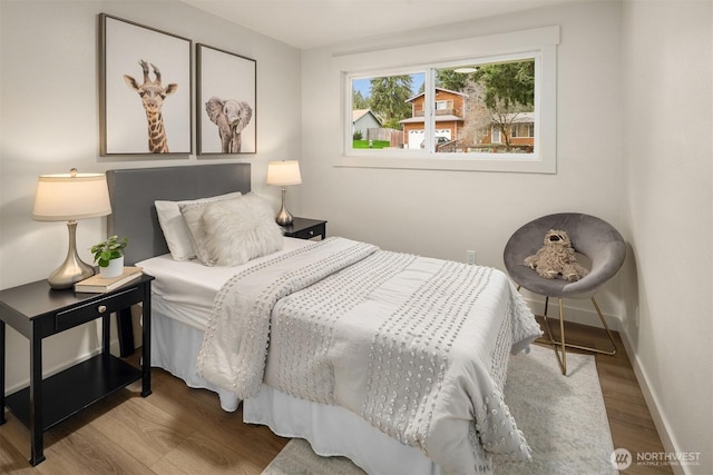 bedroom featuring wood finished floors and baseboards