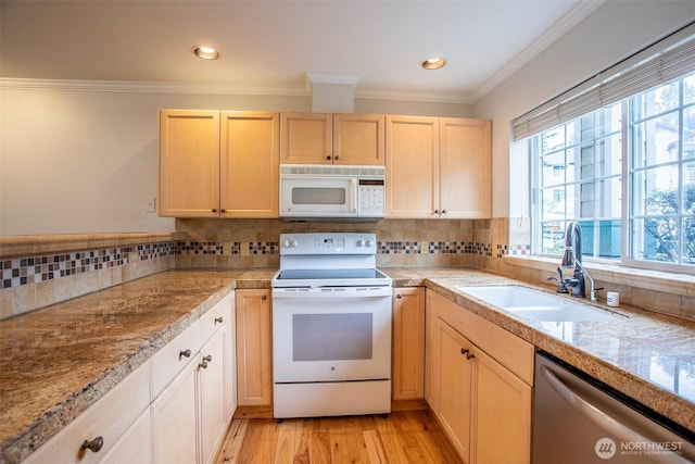 kitchen featuring white appliances, tile counters, ornamental molding, light brown cabinetry, and a sink