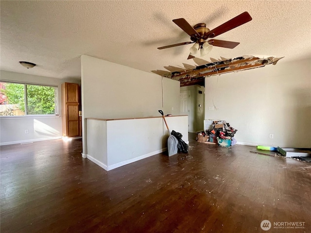 spare room featuring ceiling fan, a textured ceiling, baseboards, and wood finished floors