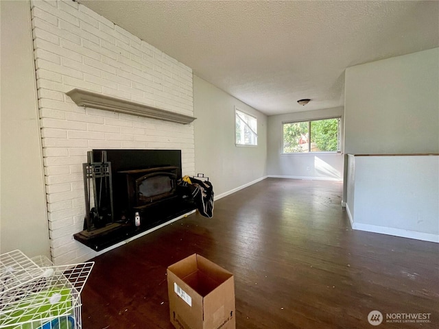 living room featuring a textured ceiling, wood finished floors, and baseboards