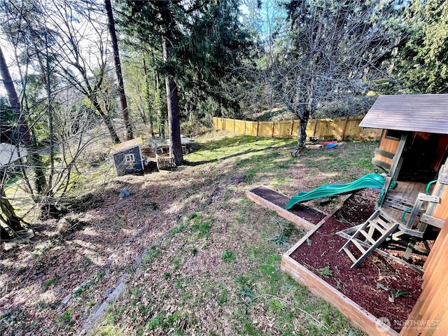 view of yard featuring a playground and fence