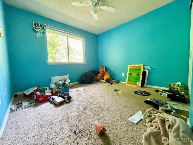 playroom with a textured ceiling, ceiling fan, carpet flooring, and baseboards