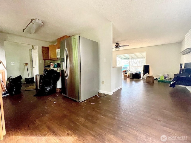 kitchen featuring a textured ceiling, white microwave, dark wood finished floors, a ceiling fan, and stainless steel fridge