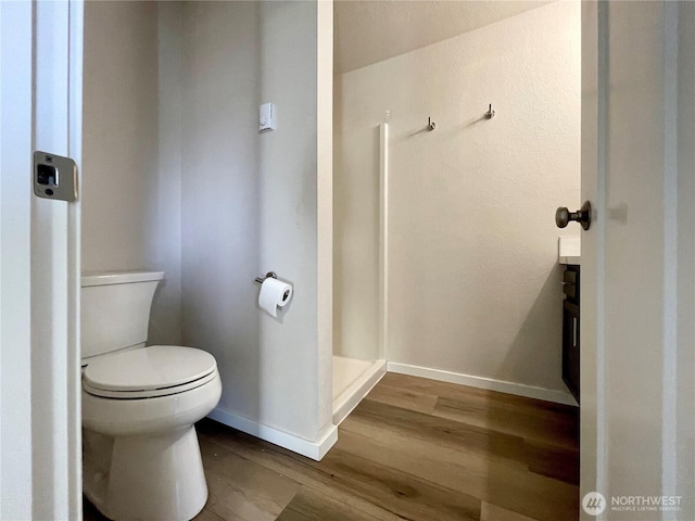 bathroom featuring wood finished floors, toilet, and baseboards