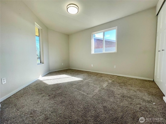 empty room featuring carpet floors and baseboards