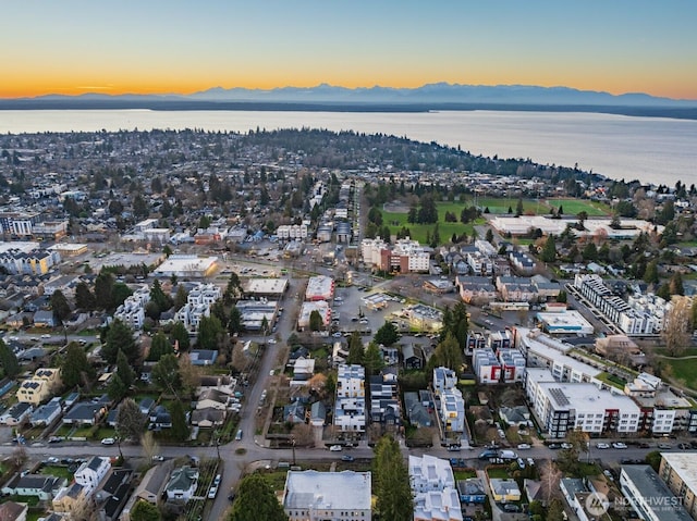 aerial view at dusk featuring a water and mountain view