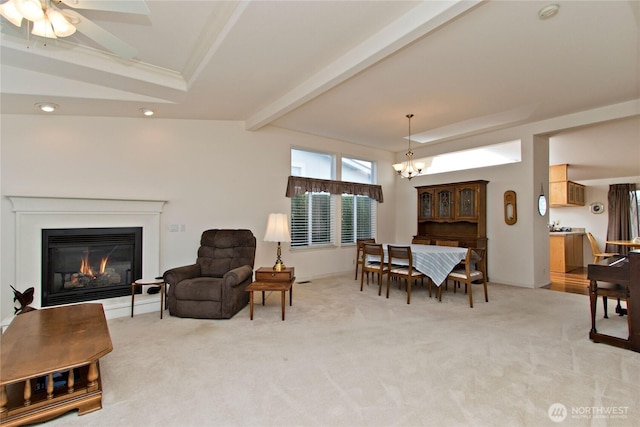 dining room featuring a chandelier, a glass covered fireplace, beam ceiling, and light colored carpet