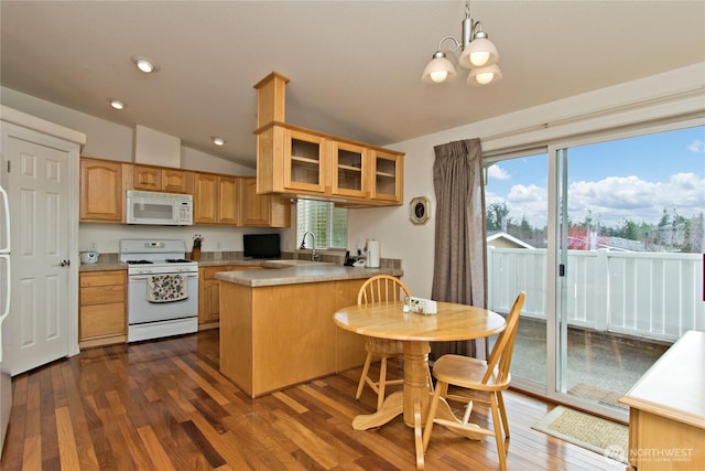 kitchen featuring a peninsula, white appliances, vaulted ceiling, dark wood finished floors, and glass insert cabinets