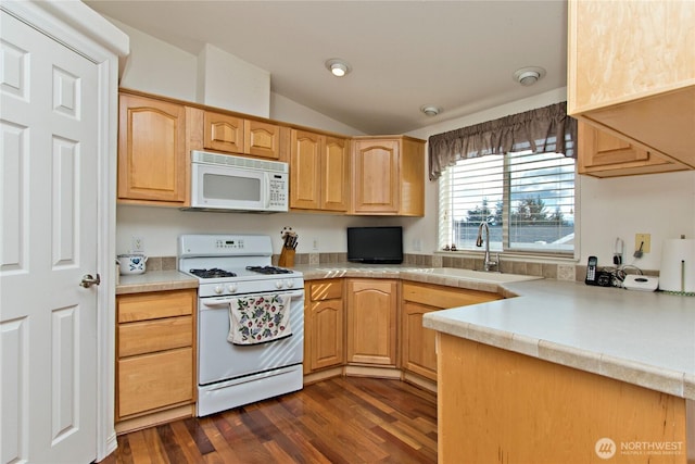 kitchen with light countertops, dark wood-type flooring, vaulted ceiling, a sink, and white appliances