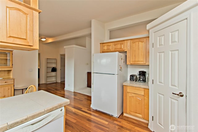 kitchen featuring white appliances, wood finished floors, and light brown cabinetry