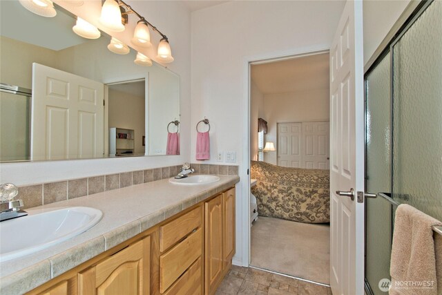 full bathroom featuring double vanity, ensuite bath, a sink, and a shower with shower door