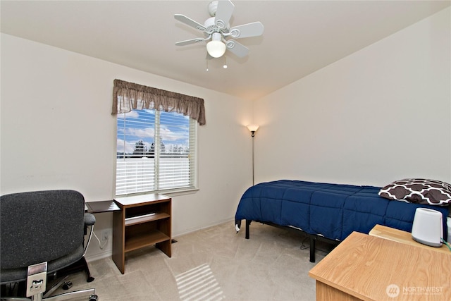 bedroom featuring light carpet, a ceiling fan, and baseboards