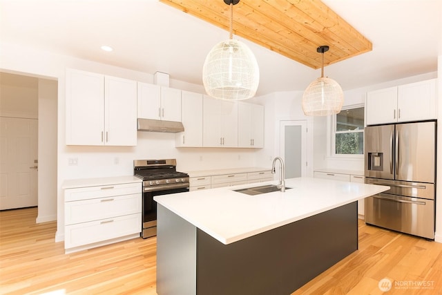 kitchen featuring appliances with stainless steel finishes, light countertops, under cabinet range hood, white cabinetry, and a sink