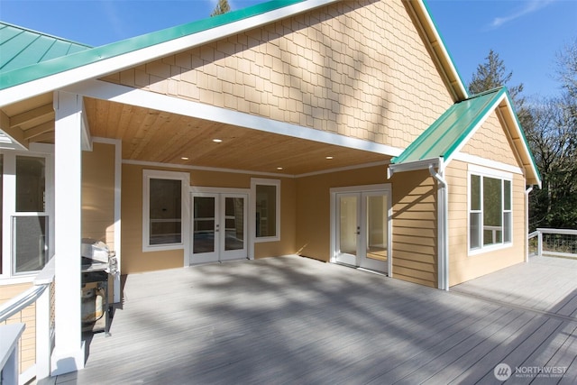 wooden terrace with a grill and french doors