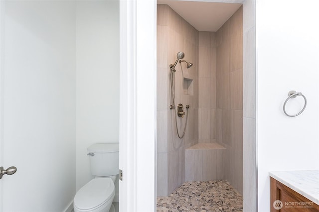 full bathroom featuring toilet and a tile shower