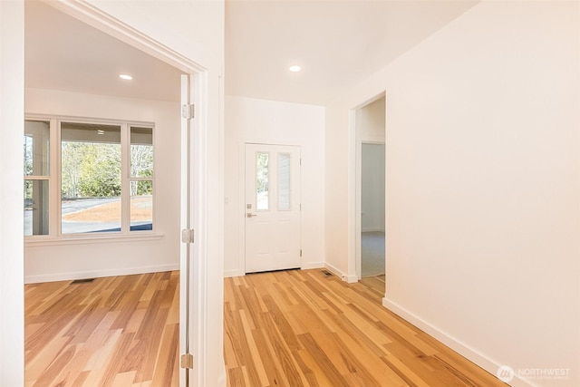 foyer featuring light wood-style floors, baseboards, visible vents, and recessed lighting