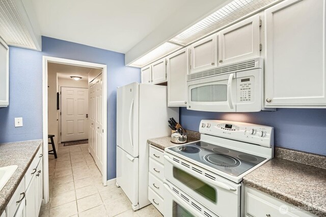 kitchen featuring white appliances, light tile patterned floors, baseboards, light countertops, and white cabinets