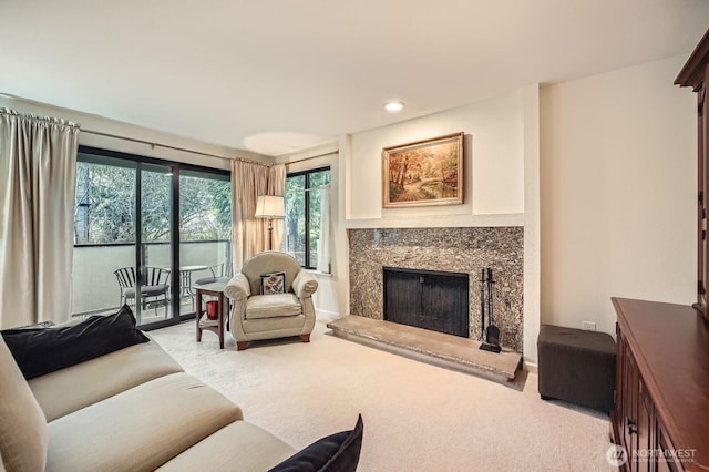 living room featuring recessed lighting, carpet floors, and a premium fireplace