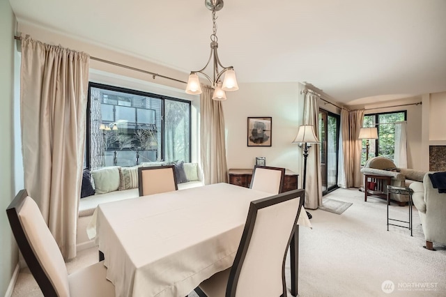 dining space featuring a notable chandelier, plenty of natural light, and light colored carpet