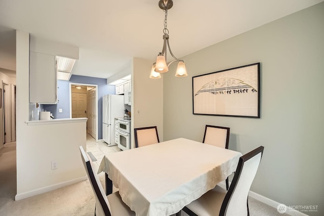 dining area featuring baseboards and light carpet