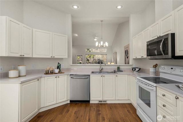 kitchen featuring dark wood-type flooring, a sink, visible vents, white cabinetry, and appliances with stainless steel finishes