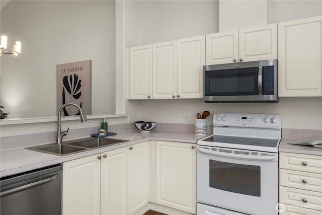 kitchen with appliances with stainless steel finishes, white cabinets, light countertops, and a sink